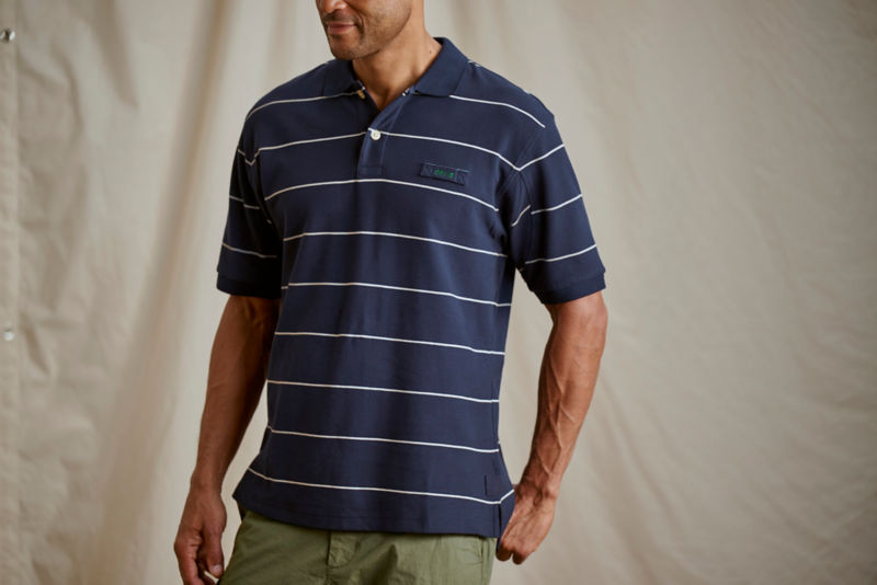 Man wearing navy polo and olive pants