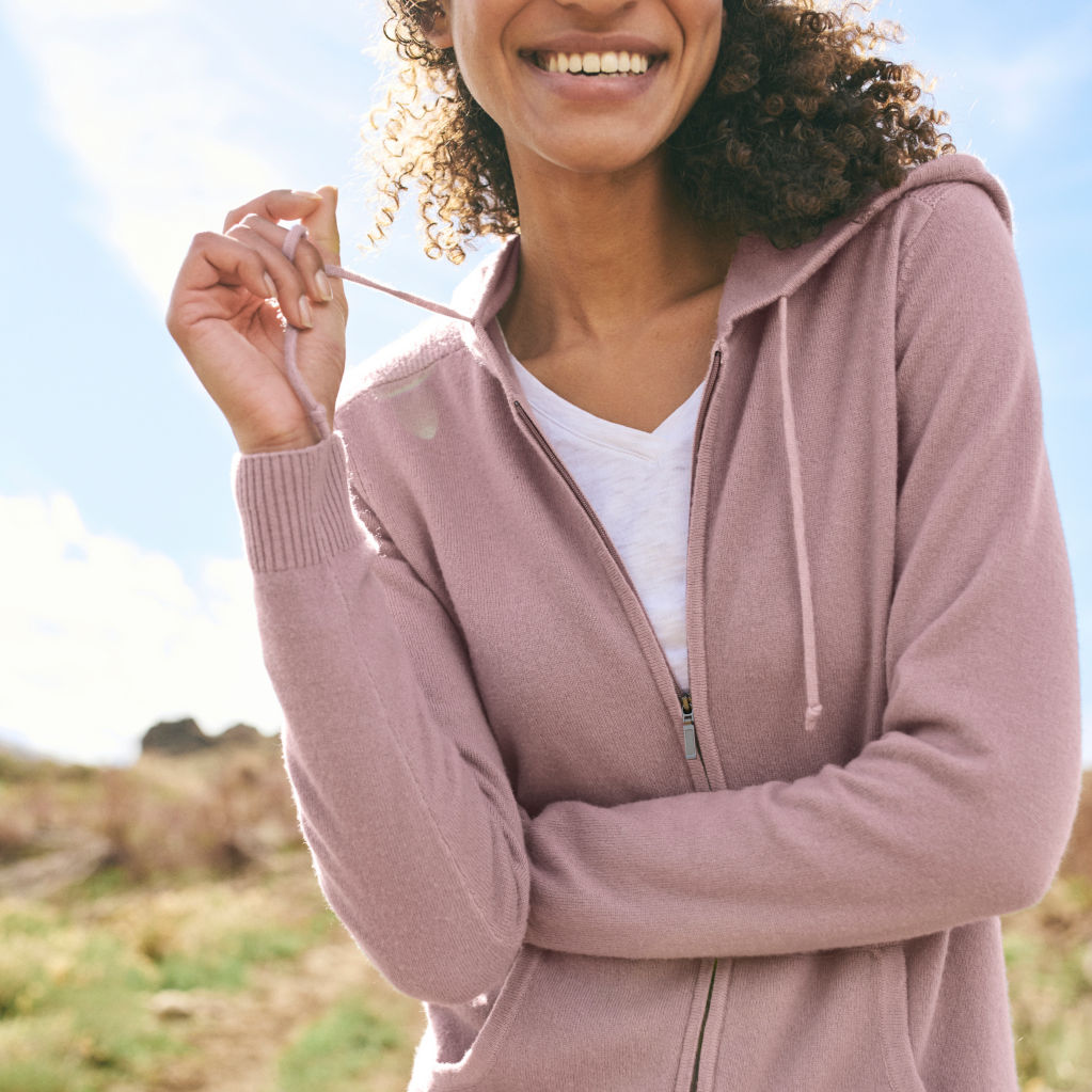 Woman with Garment-Dyed Cashmere Hoodie poses outdoors.