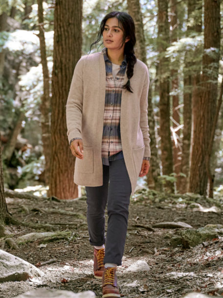Woman in Feather Cashmere Long Open Cardigan walks through a forest.