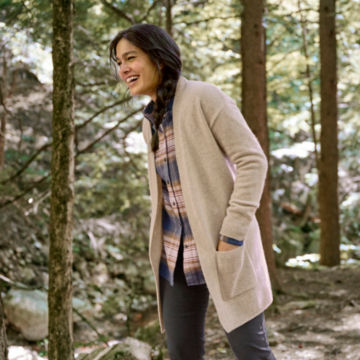 Woman in Cashmere Long Open Cardigan walks through the woods.