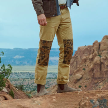 Man in 1971 Pieced Angler Chinos stands atop a rocky outcropping.