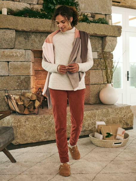 Woman in Oatmeal Heather Quilted Turtleneck Sweatshirt wraps gifts next to a roaring fire.