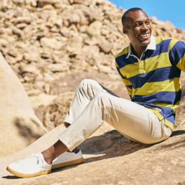 Man in Ranger Modern Chinos sits on a rock.
