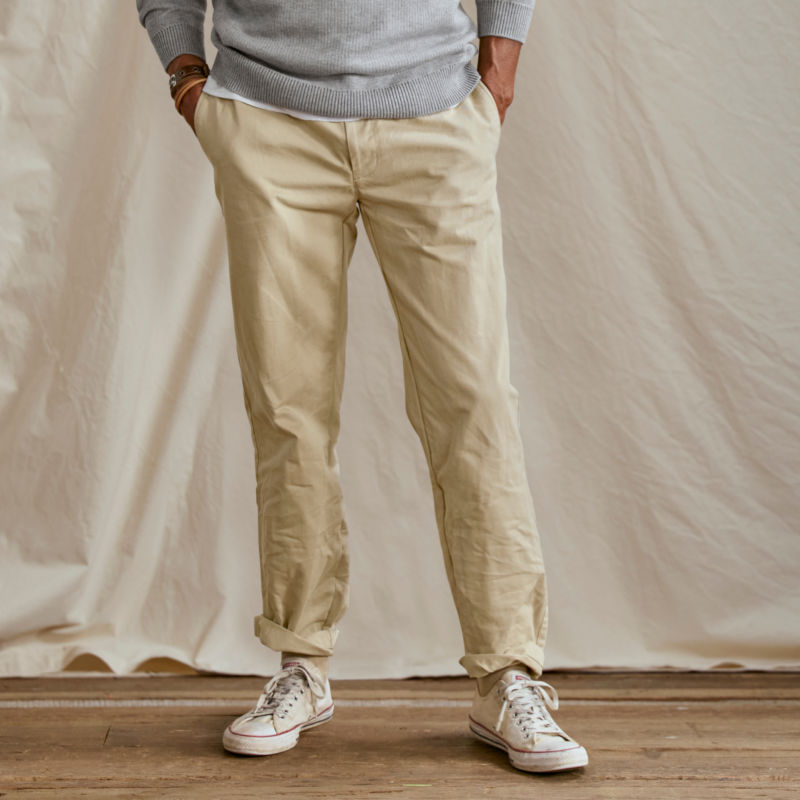 A waist-down view of a model wearing a a pair of rolled up chinos.