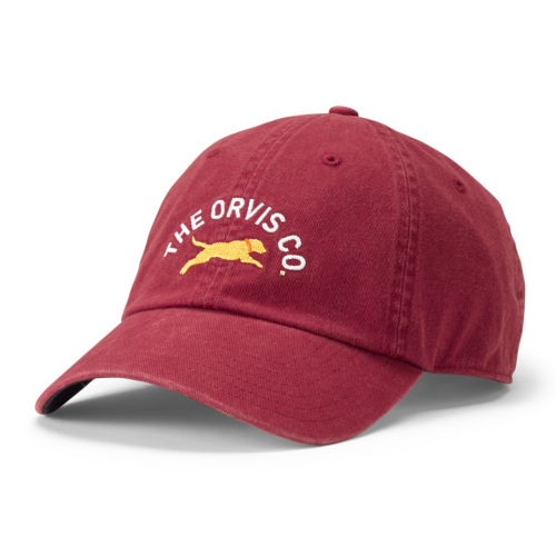 A red cotton ball cap with a golden Lab embroidered on the front along with the words: The Orvis Co.. 