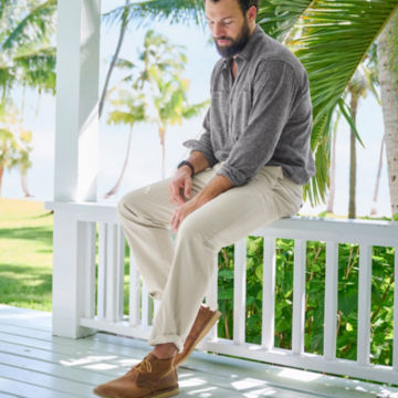 Man in Ultimate Khakis sits on a railing.