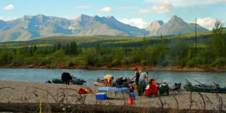 A campsite along the river with a view of a mountain range