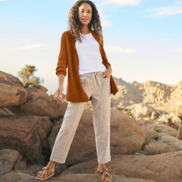 Woman in Hemp Blend Classic Cardigan poses for the camera in a rocky outcropping.