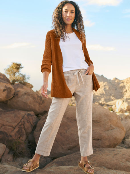 Woman in Caramel Hemp Blend Classic Cardigan and Purpose Linen Natural Ankle Pant poses for the camera in the desert.