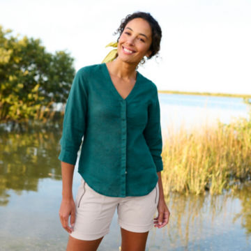 Woman in Performance Linen 3/4 Sleeve Shirt stands on a dock next to a marsh.