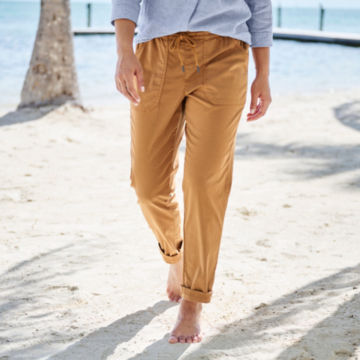 Woman in Explorer Natural Straight-Leg Ankle Pant walks up from the shoreline.