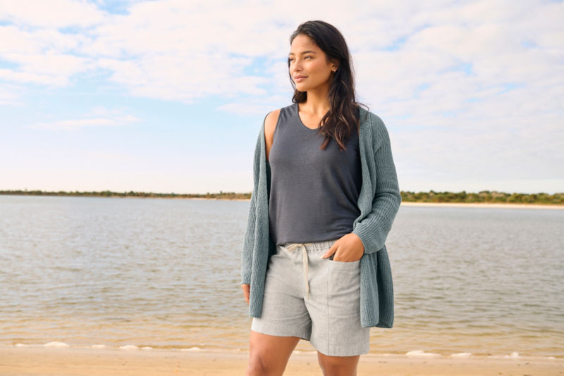 Woman in Performance Linen Relaxed Fit Short walks along a beach.