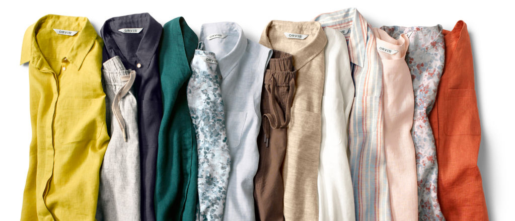 Colorful linen clothing, folded vertically and laid flat on a white background.
