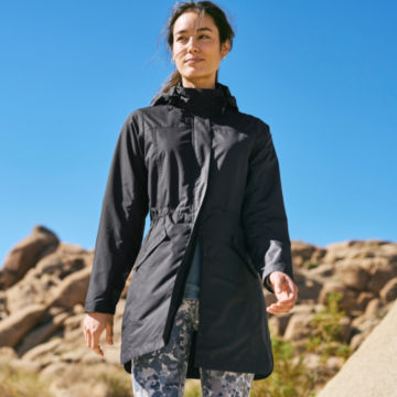 Woman in Pack n Go Jacket walks down a desert trail.
