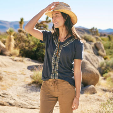 Woman in Carbon Embroidered Short-Sleeved Tee walks down a desert trail.