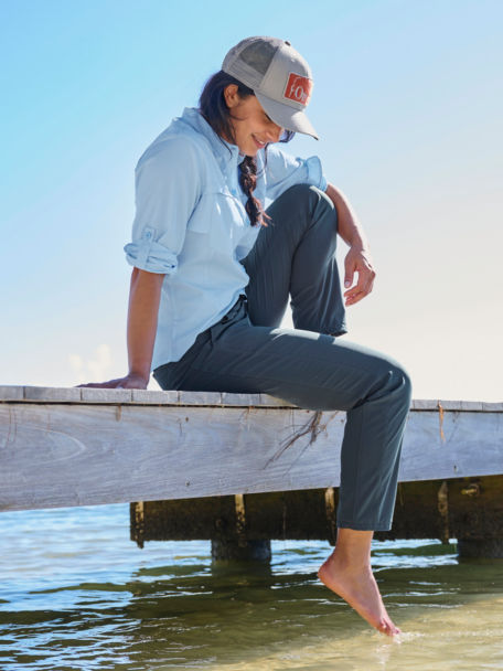 Woman sitting on a dock dipping her toes int he water