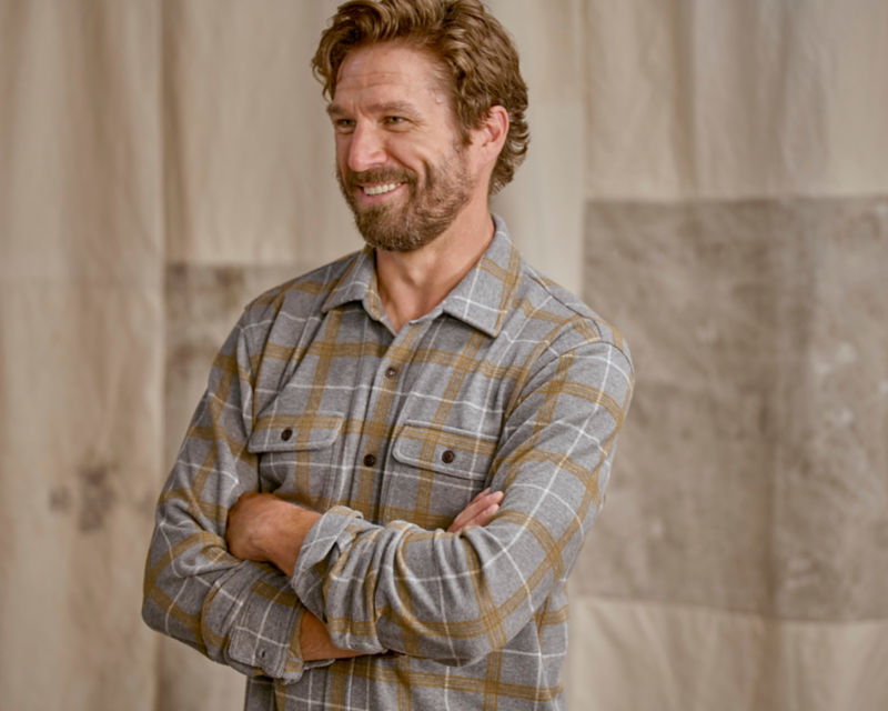 Model wearing grey and yellow plaid flannel