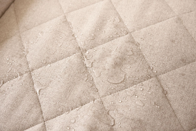 An up close shot of water beading on the khaki fabric