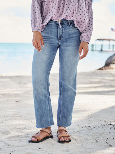 Woman wearing jeans on the beach with sandals