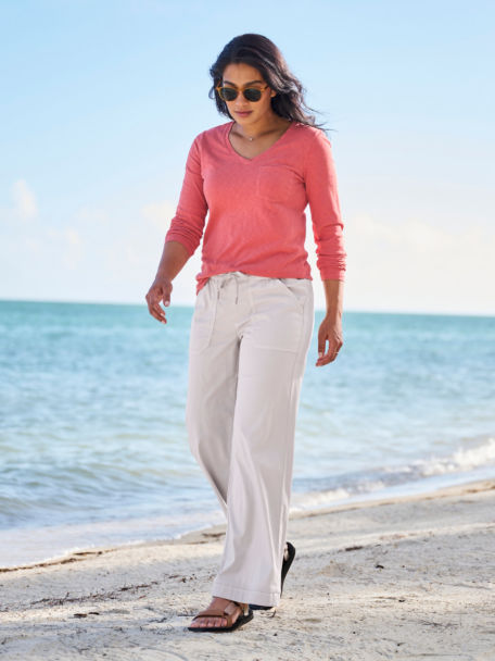 Woman walking the beach in red long sleeve v neck