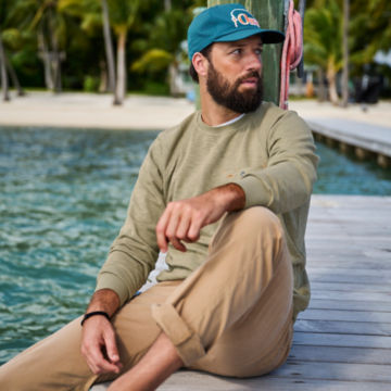 Man in 5-Pocket Stretch Twill sits on a dock.