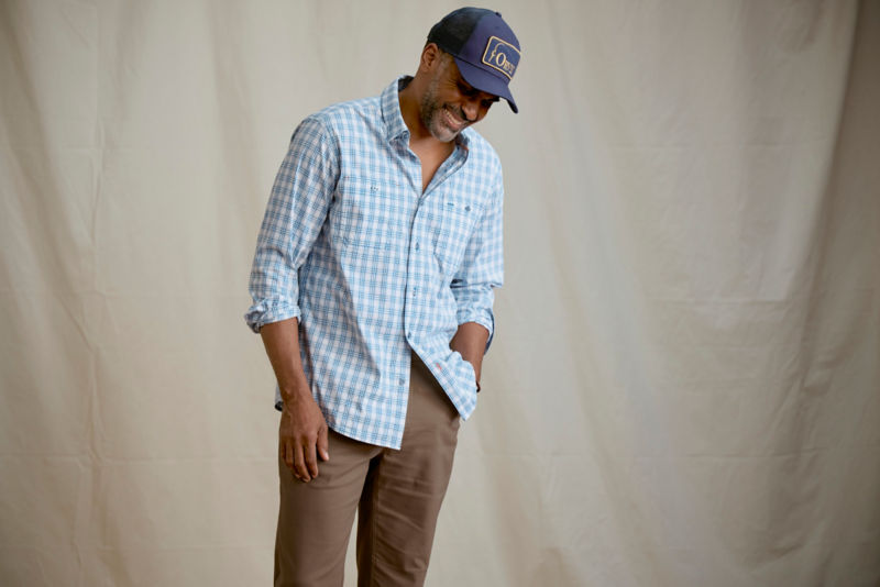 Man wearing blue plaid shirt in a studio.
