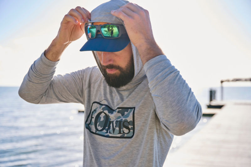 Man wears DriCast Hoodie for protection from the sun on the beach