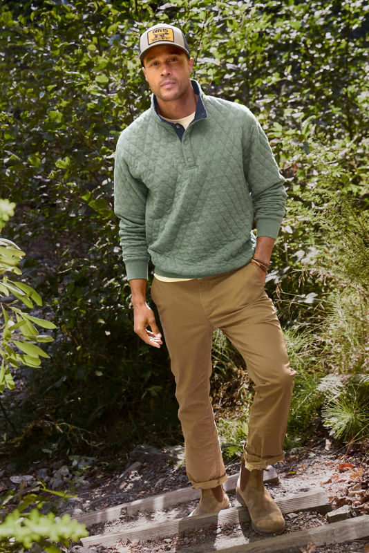 Man wlaking in the woods with aloe 1/4 snap and 5 pocket pants