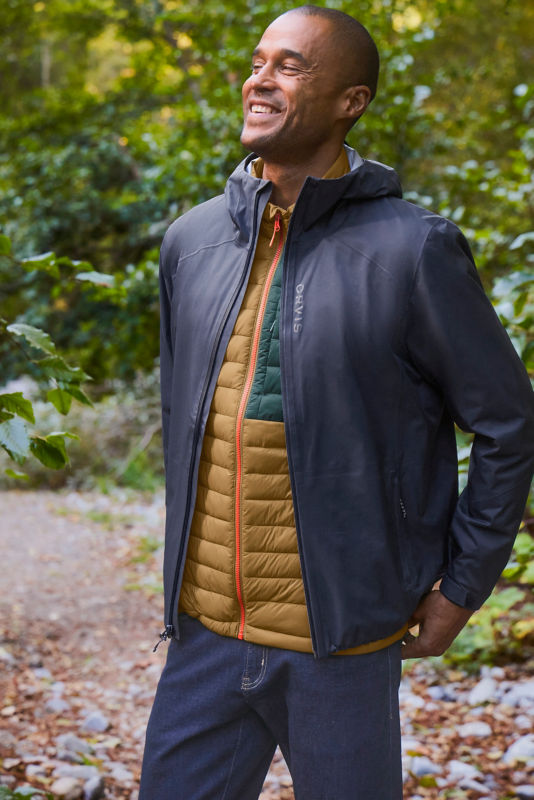 Man wearing drift vest with ultralight rain jacket and jeans