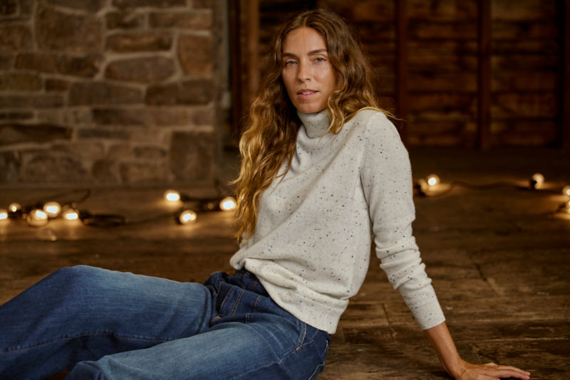 Woman in cashmere turtleneck sitting by fire