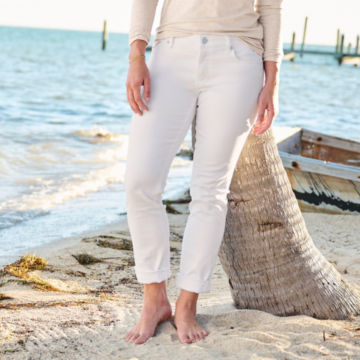 Woman in Kut from the Kloth® Catherine Boyfriend Jeans leans on a palm tree.