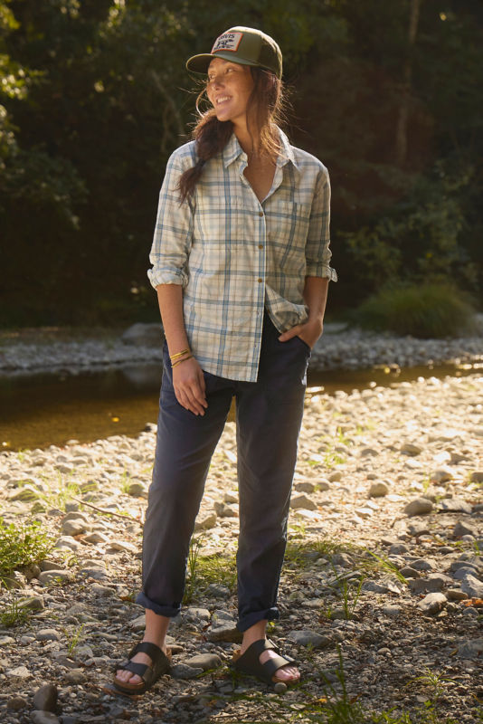 A waist-down view of a model wearing blue blue high rise pants rolled at the cuff.