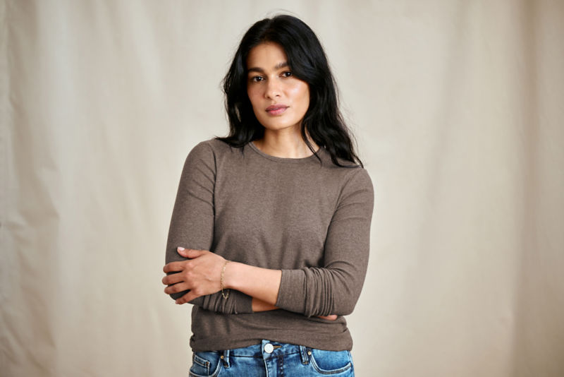 A waist-up view of a model wearing a mushroom-colored long-sleeve t-shirt.