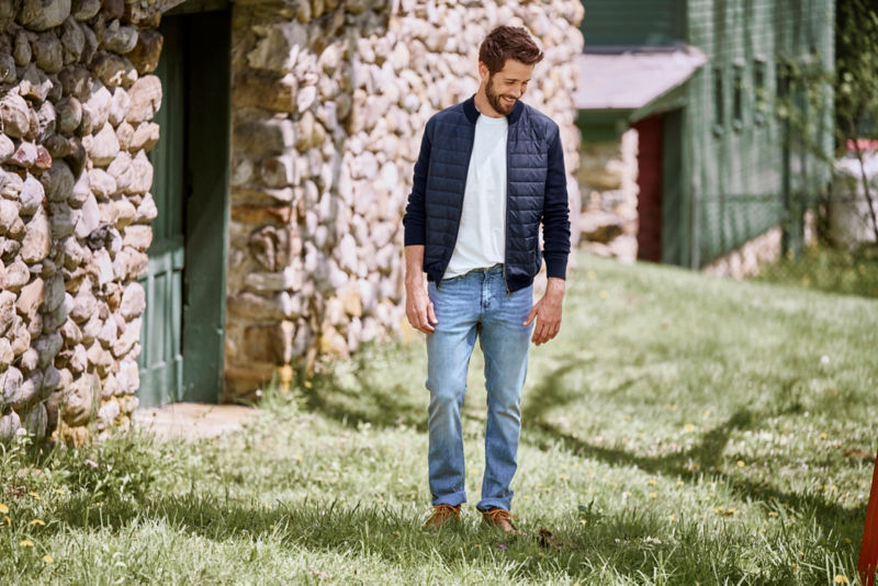 Model wearing light wash jeans in field
