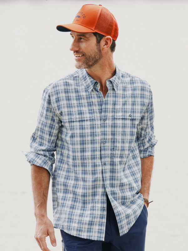 A model wearing a button-down, blue and white plaid tech shirt.