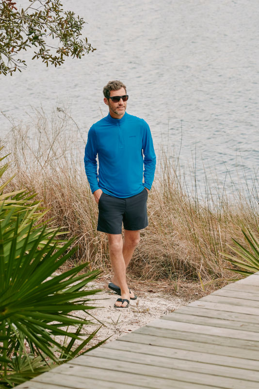 A model wears a bright blue, long-sleeve tech shirt.