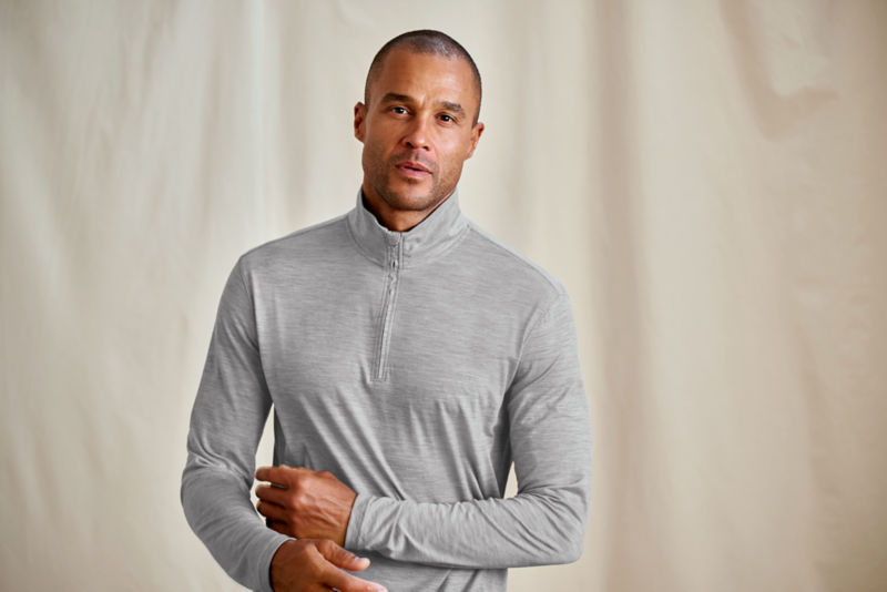A model wearing a gray quarter-zip performance t-shirt.