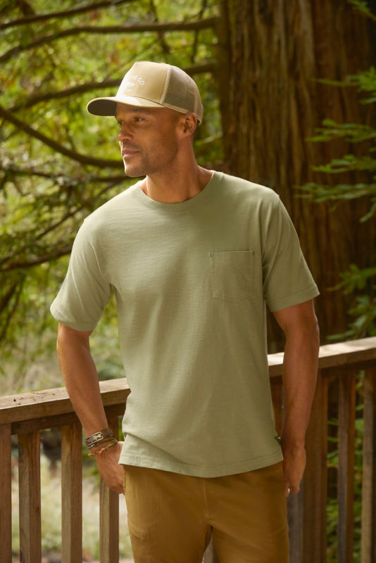 Man wearing green t-shirt standing on a deck.