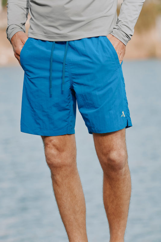 A waist-down view of a model wearing bright blue tech shorts.