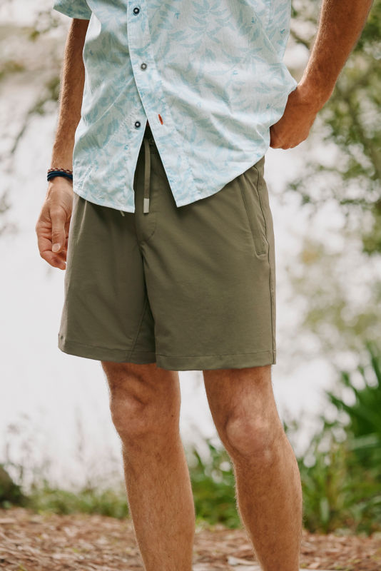 A detail image of a model wearing green shorts.