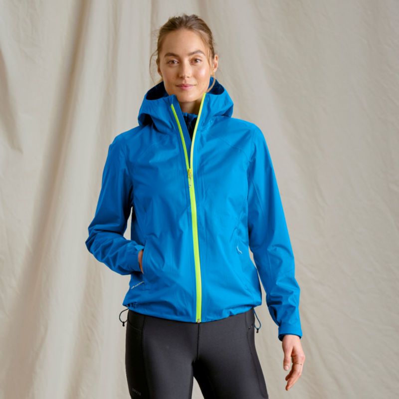 A model wearing a bright blue rain jacket with bright yellow-green accents.