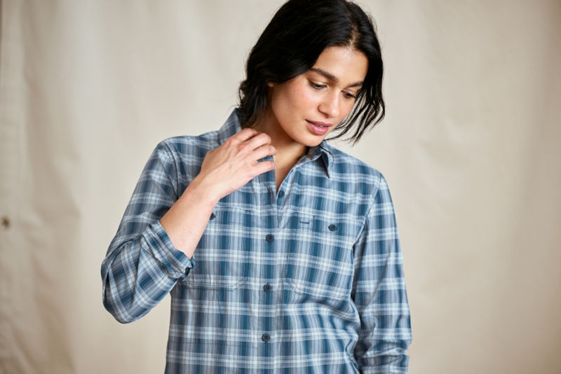 A waist-up view of a model wearing a blue and white plaid performance button-down shirt.