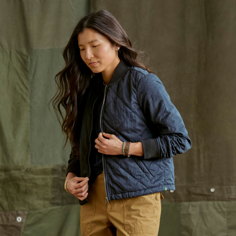 A model wearing a navy blue bomber jacket.