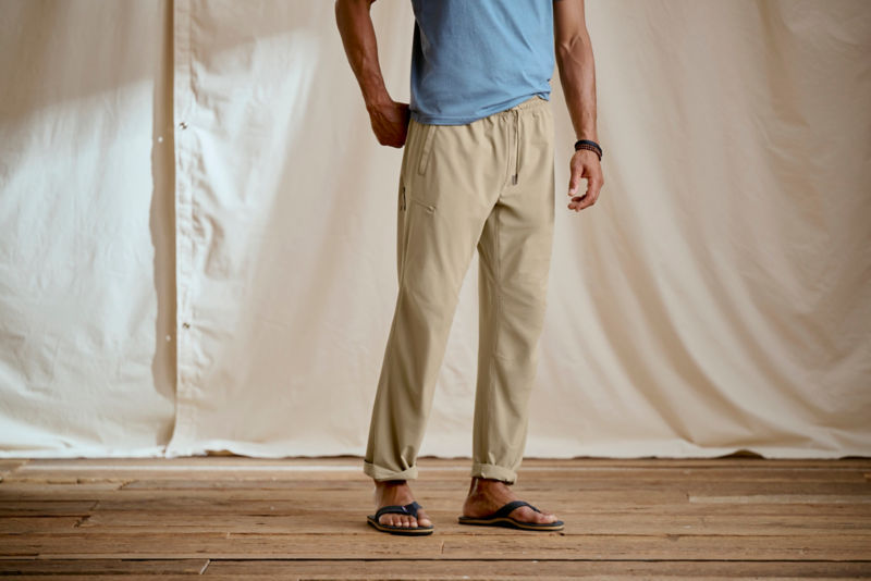 A waist-down view of a man wearing relaxed fit pants.