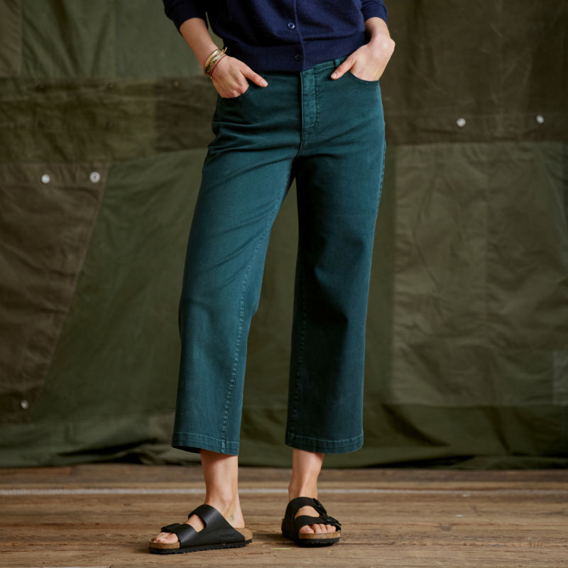 A waist-down view of a model wearing a pair of teal wide leg Kut from the Kloth jeans.