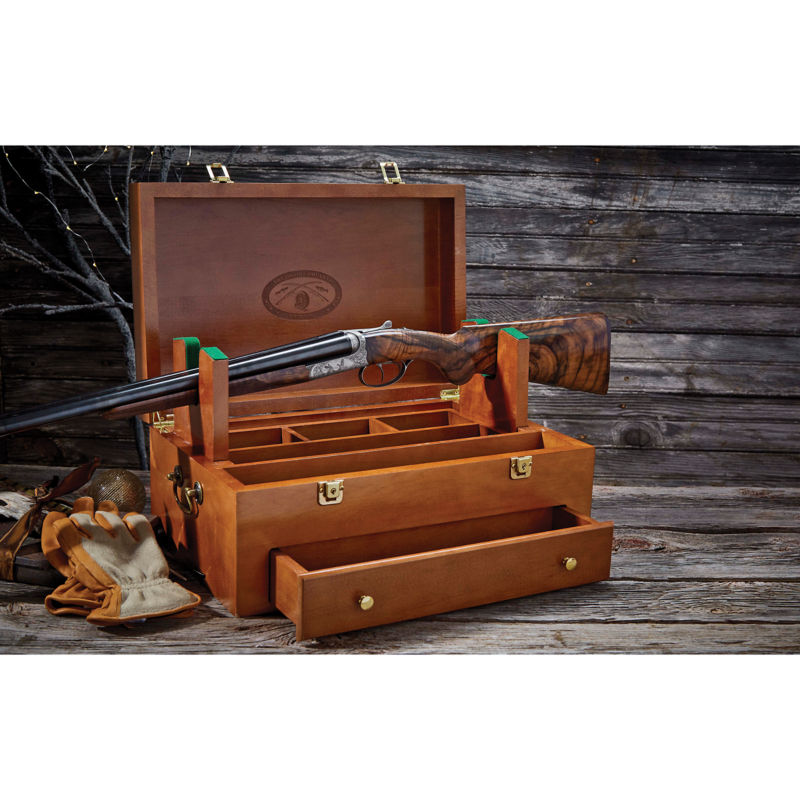 A shotgun placed on a wooden cleaning box.