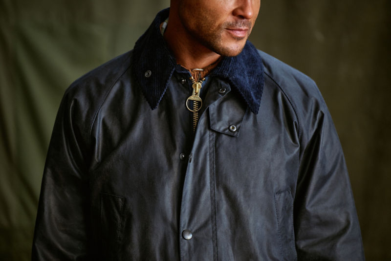 A model wearing a navy waxed cotton Barbour&reg; jacket.
