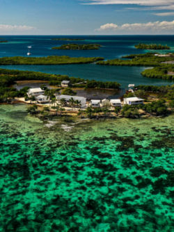 A drone view of a fishing lodge on beautiful Belize waters.