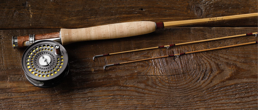 A bamboo fly rod on a dark wooden table