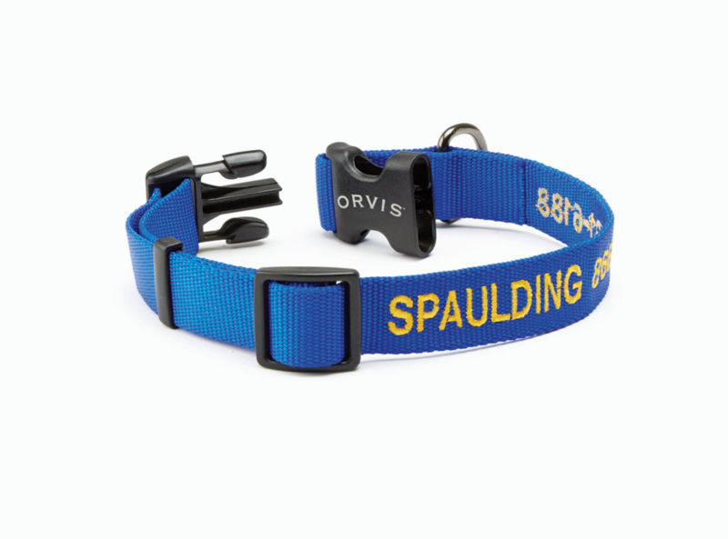 A blue personalized dog collar with the name Spaulding embroidered on it.